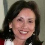 A woman smiling, wearing a red top.