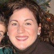 A person smiling, wearing a dark turtleneck, with blurred background.