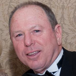 A man in formal attire smiling.