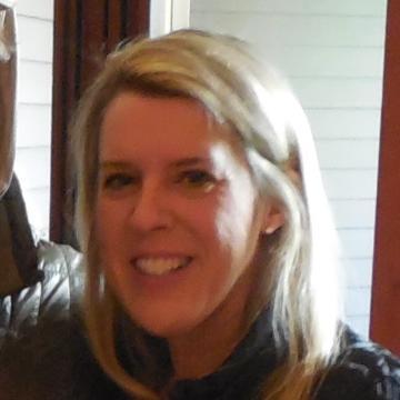 A person smiling indoors near a window.