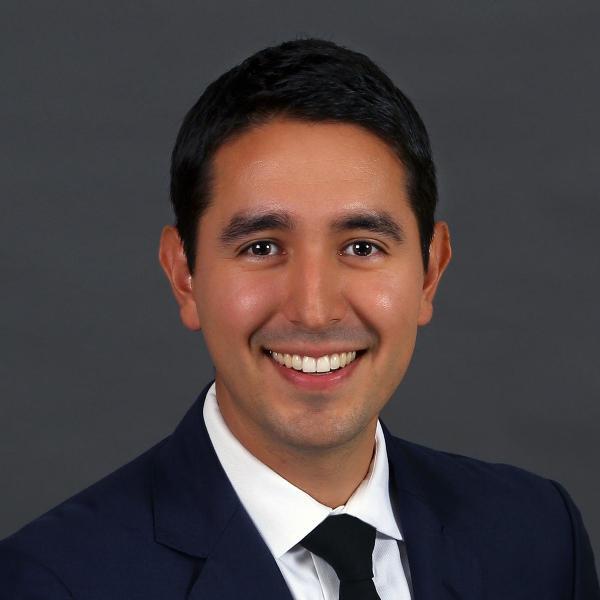 A person in a suit smiling.