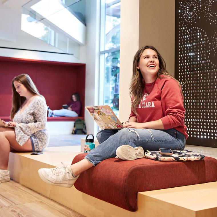 A student working on her laptop on campus. 