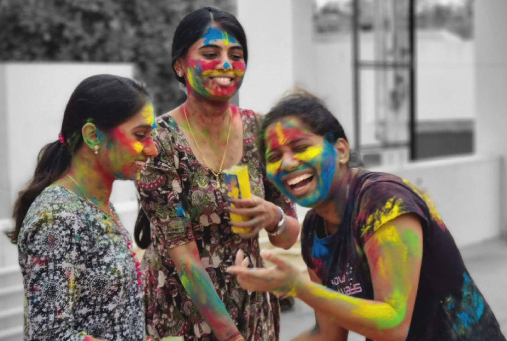 Decorative; three students covered in Holi colors 