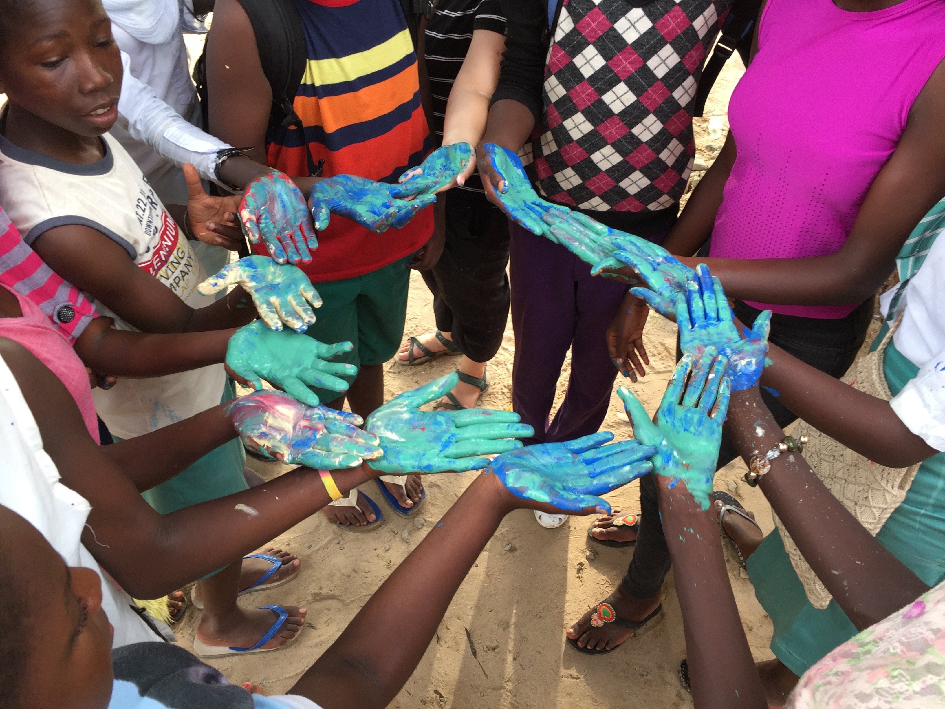 Children holding a colorful painted snake craft in a circle.