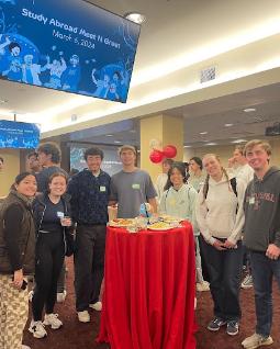 Group of students smiling around a table