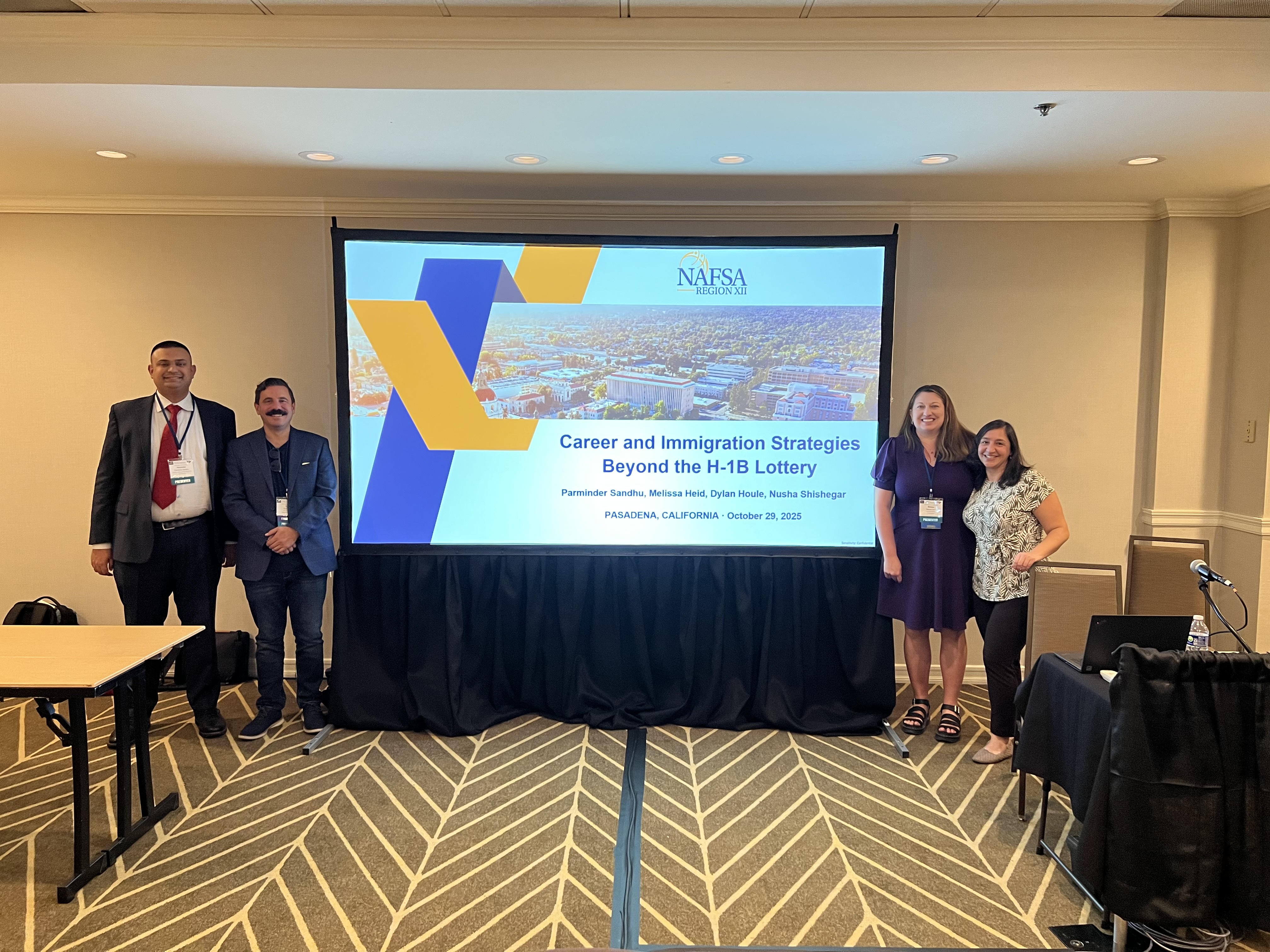 Decorative; panelists smiling in front of projector screen