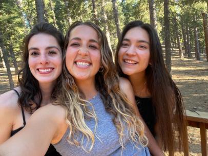 Three women smiling while taking a selfie