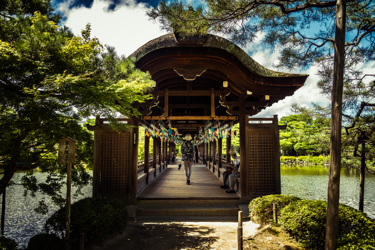 Heian Shrine in Kyoto, Japan. wind chimes carry the wishes of countless people, and a person in the center of the frame passes through it all calmly