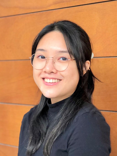 Professional headshot of Thuy Tran on orange background