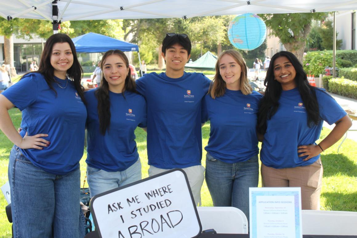 Decorative; five study abroad peer advisors smiling at a tabling event