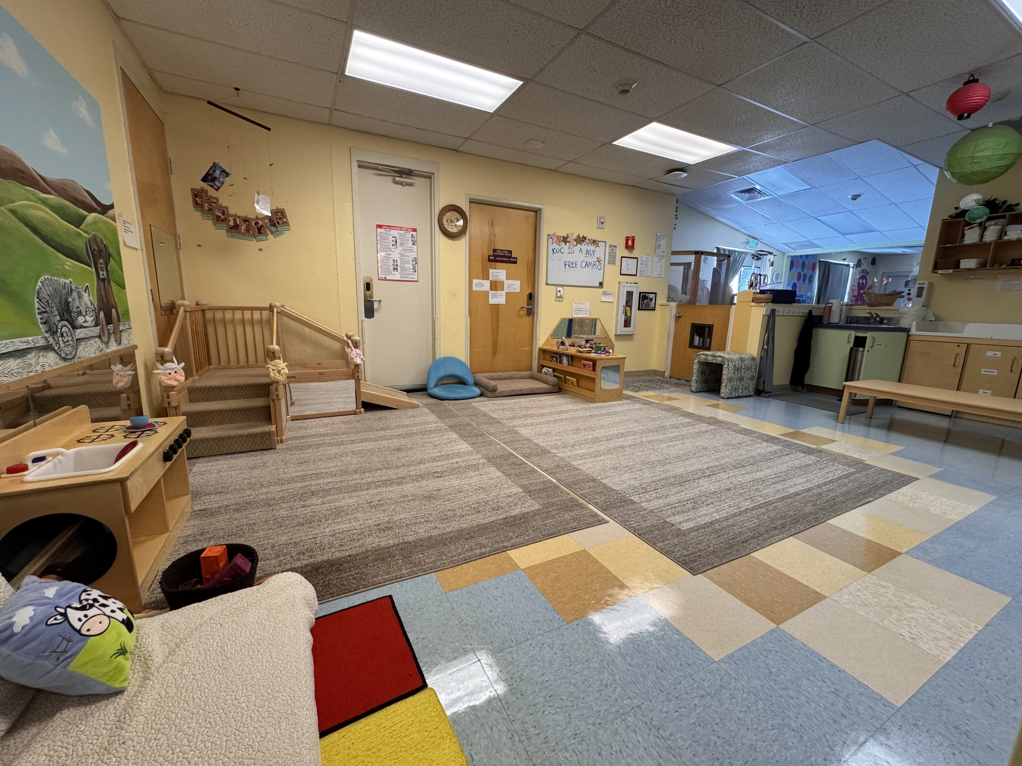 starfish nursery room which is mostly an open floor with big play carpets and a very young child staircase style junglegym