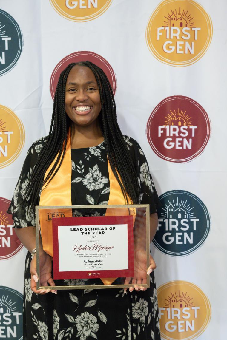 A woman holding a certificate in a gold frame