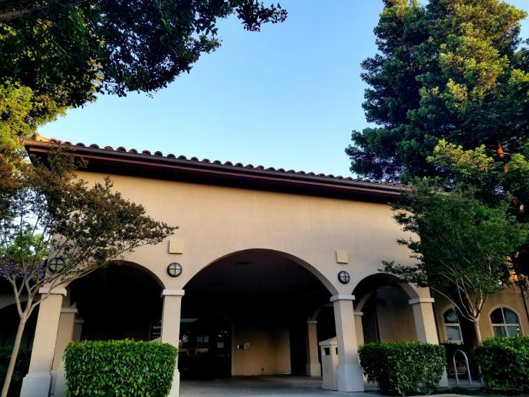 Front view of a house with arches and greenery.