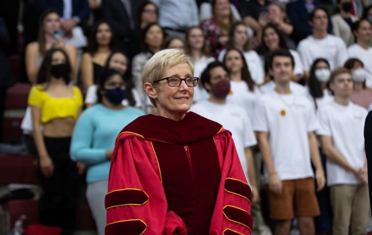 President Sullivan at her inauguration with students on bleachers behind her