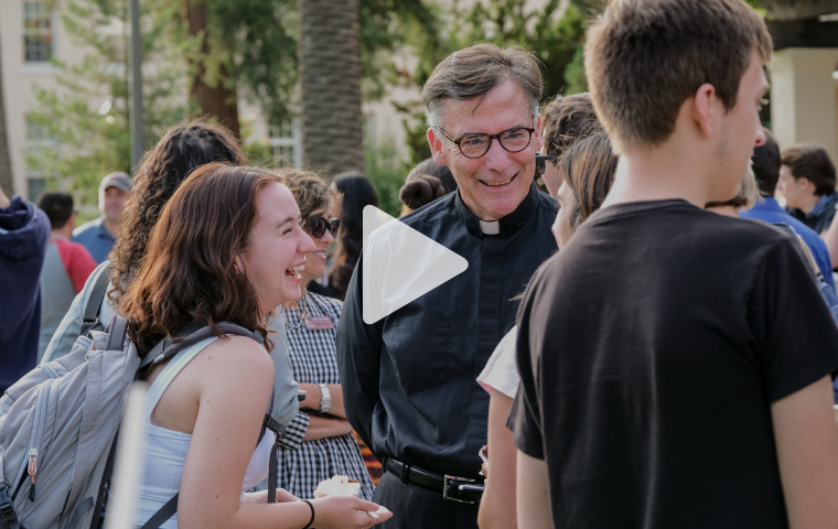 A group of people talking and laughing outdoors.