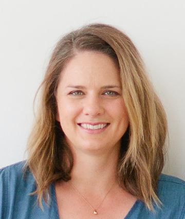 A woman smiling in a headshot against a plain background.