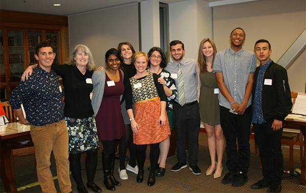A group of nine people posing indoors at an event.