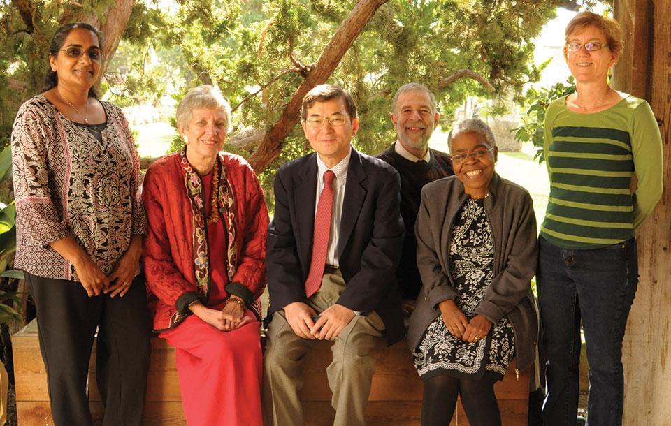 Six individuals posing together under a tree for the 'Faculty Awards'.