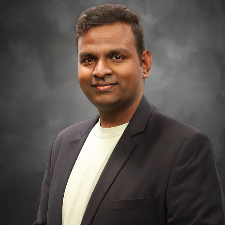 man in blazer smiles at camera 
