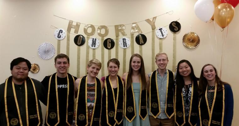 Johnson Scholars Class of 2017 smile with their graduation stoles under a banner that says congrats! image link to story