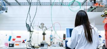 A person in a lab coat working in a laboratory.