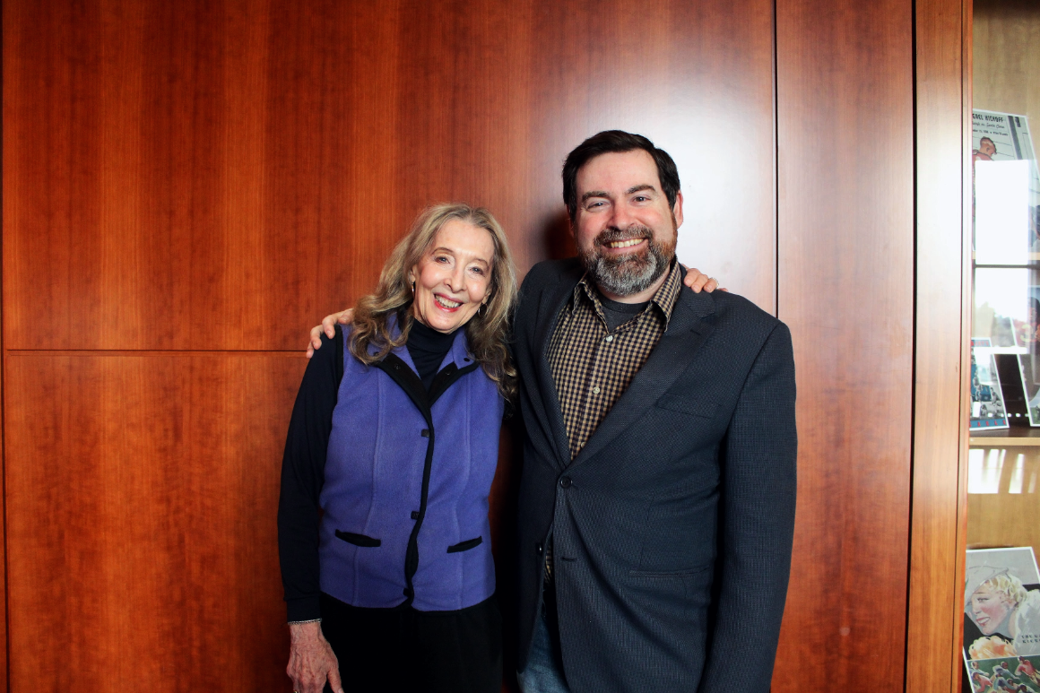 a woman and man stand together smiling