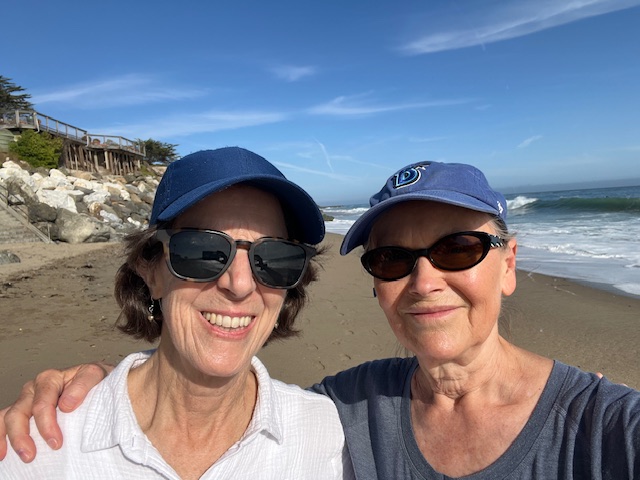 two women in baseball hats at beach