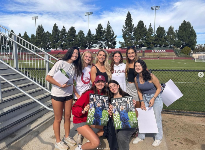 Sevem Women's Club Soccer members smile with signs signed by Julie Ertz. She is also in the picture!