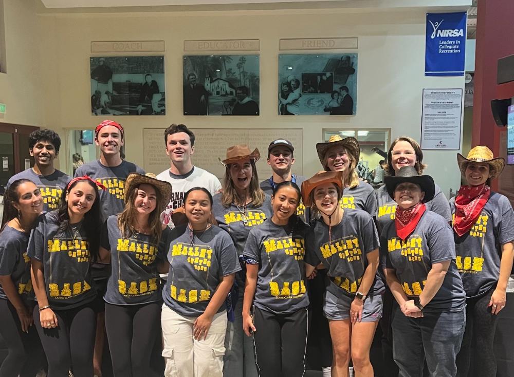 12 student coordinators and 3 full time staff celebrating the end of Malley Bash 2025