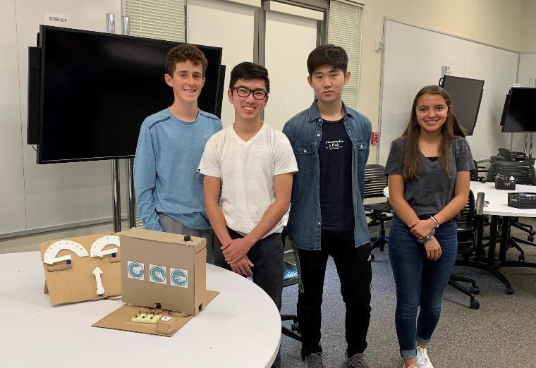 Four Students standing behind their robot.