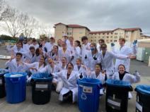 Group standing around garbage cans after a waste characterization