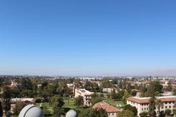 An overhead view of Santa Clara University's campus with the city of Santa Clara in the distance.