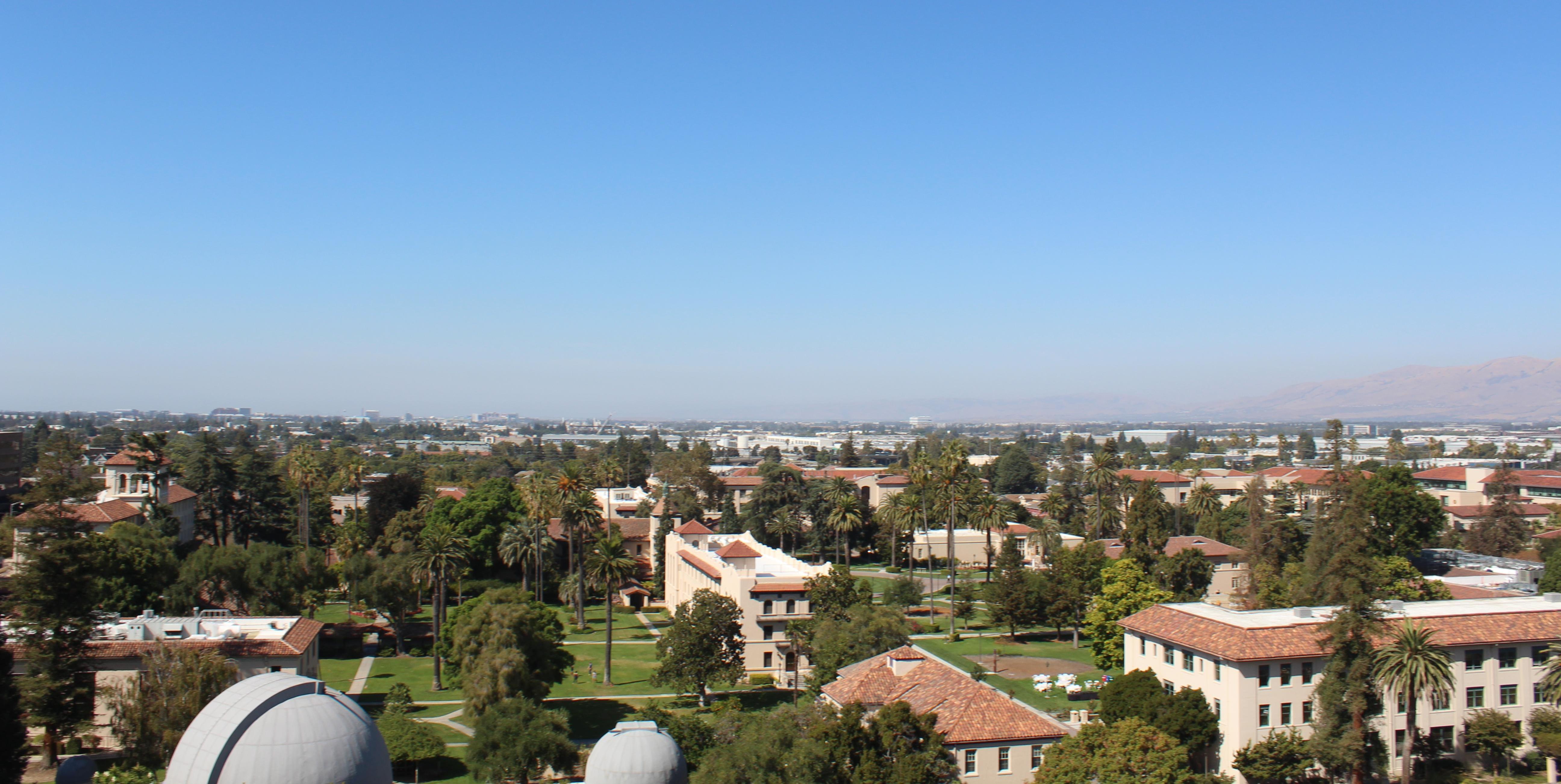 An overhead view of Santa Clara University's campus with the city of Santa Clara in the distance.