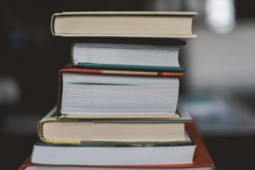 Stack of page leaf-facing books. Photo by Claudia, Unsplash.