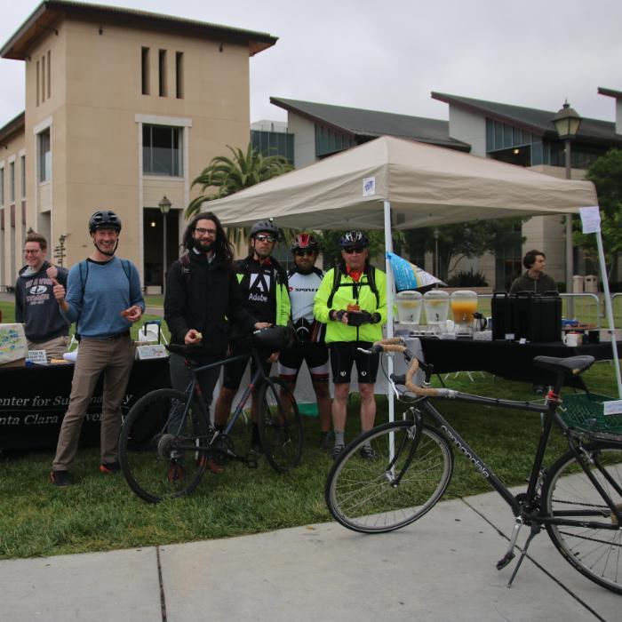 SCU bike commuters and Center for Sustainability staff waving and smiling at the energizer station