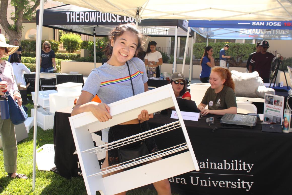 A student smiling holding a shelf at the 2019 Welcome Weekend Bronco Surplus booth