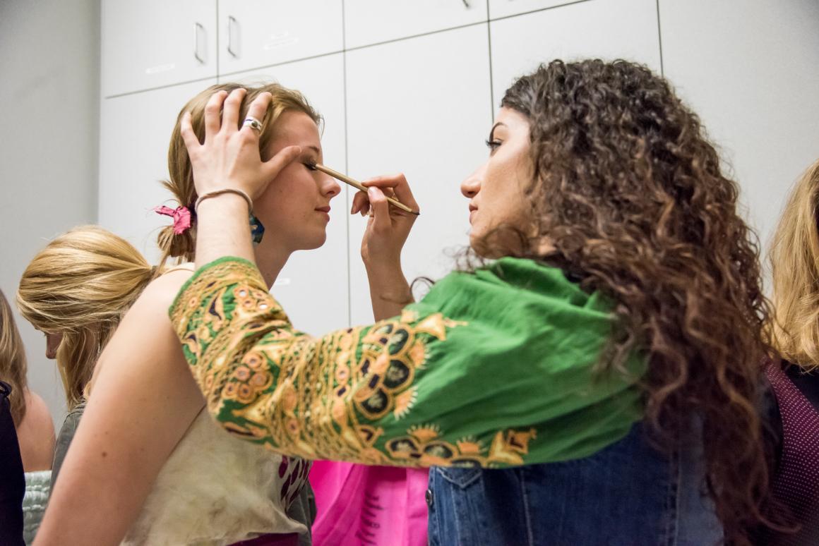 A student putting eyeshadow on a model. Photo by Joanne Lee