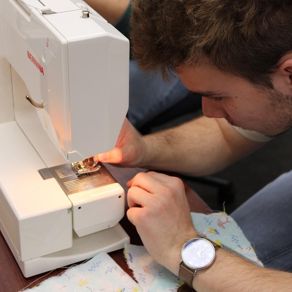 A student using a sewing machine on a Maker Night