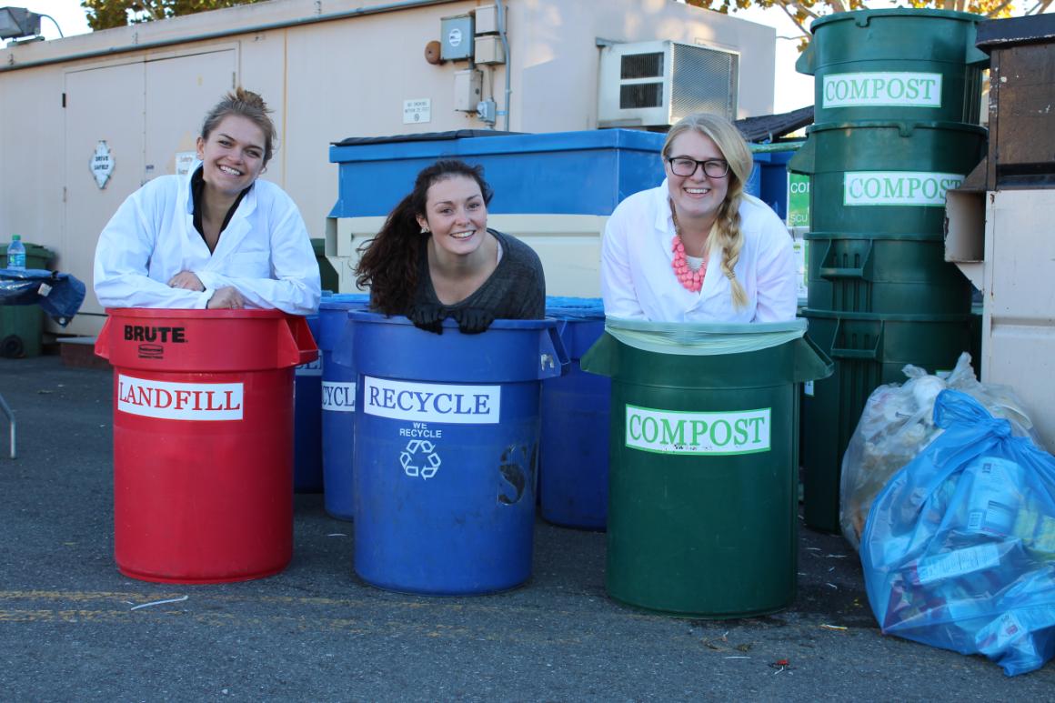 3 students, including the waste diversion intern Kayla Wells, posing in trash cans at a waste characterization (Nov, 2015)