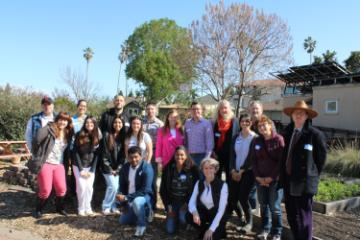 A large group of faculty, staff, and students smiling at the Forge Garden