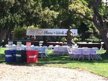 Multiple waste bins of different colors at outdoor event.

