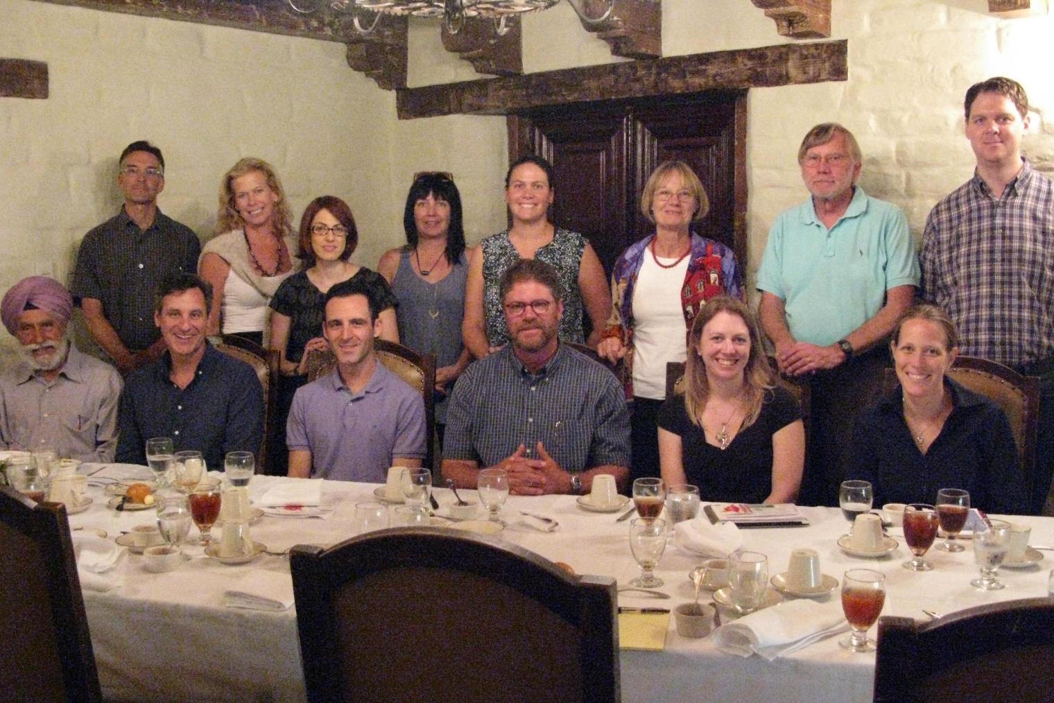 A group of faculty smiling in a dining room