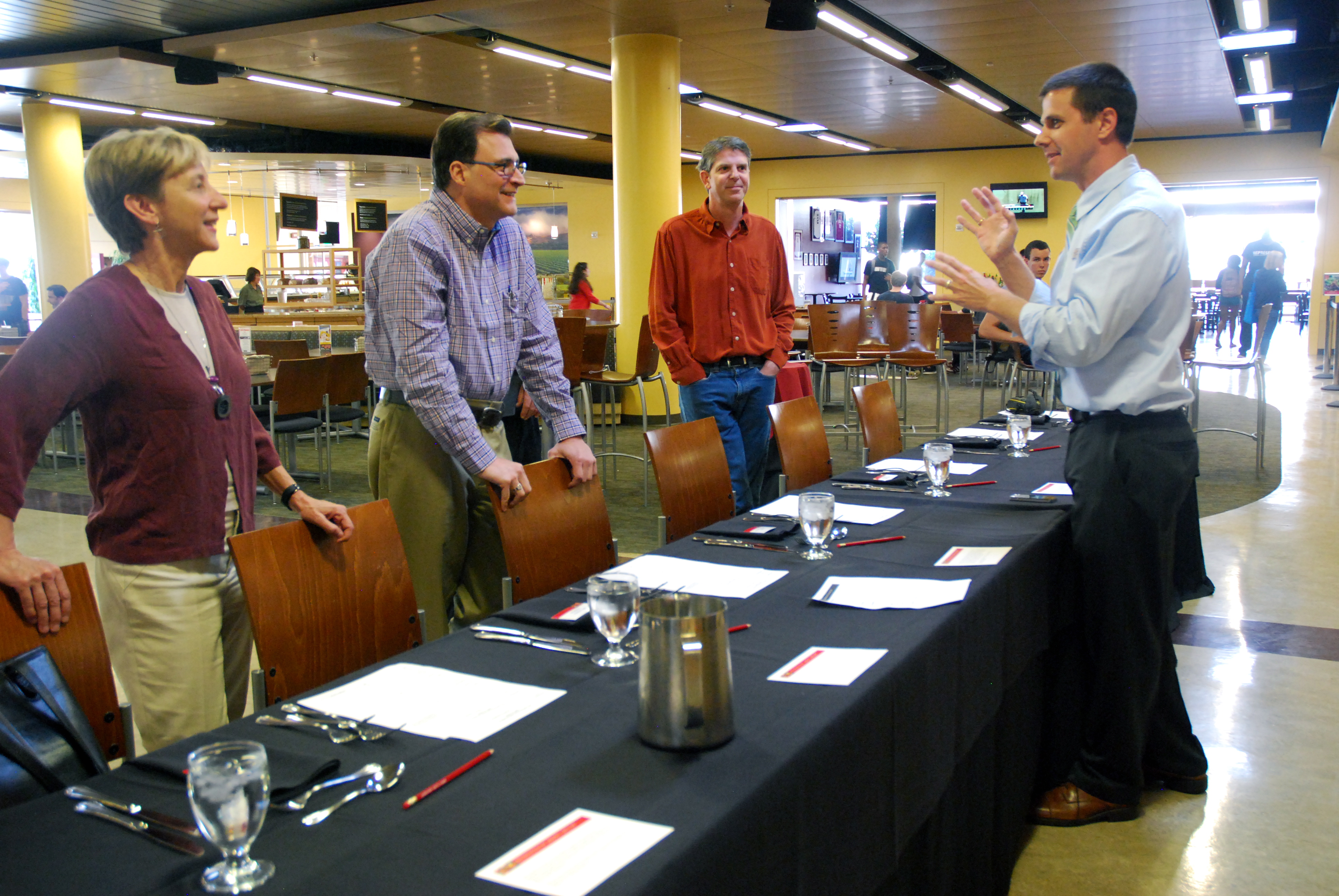 People standing around a table at an event or meeting.