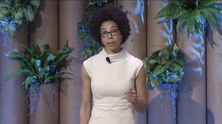 Marine biologist, policy expert, and conservation strategist Dr. Ayana Johnson speaks on stage with plants in the background