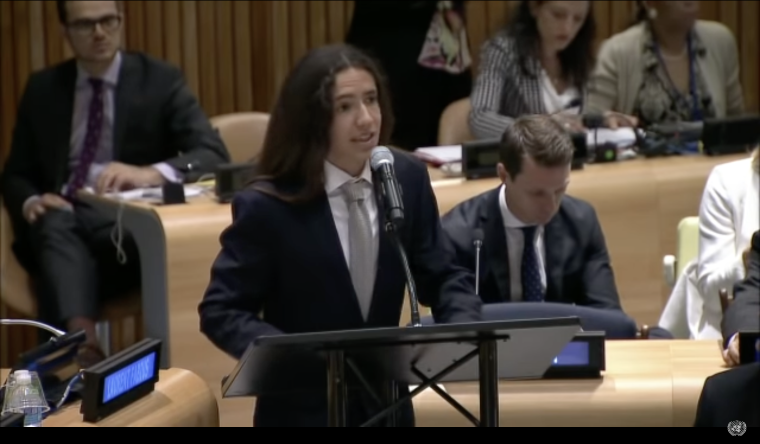 Indigenous climate activist Xiuhtezcatl stands at a podium addressing the United Nations