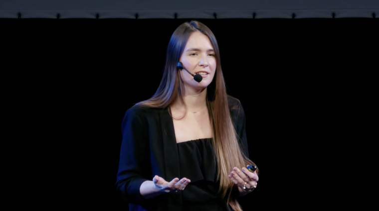 Natalie Haas speaks on stage at a TED event