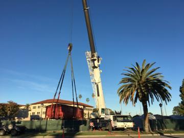 Mobile crane lifting a dumpster out of a jobsite