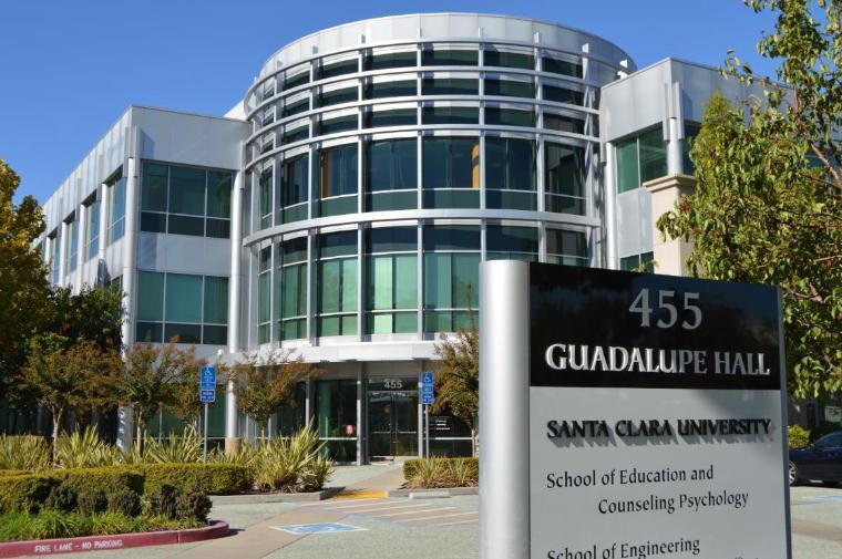 Modern glass building labeled Guadalupe Hall with sign in front displaying ASU CAMPUS, NUDYUS BUILDING.