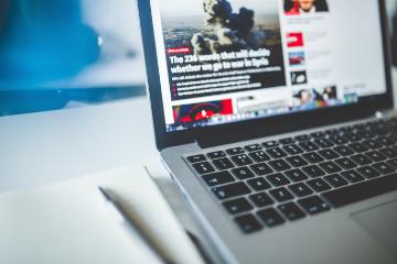 Pen, paper, and a laptop on a desk 