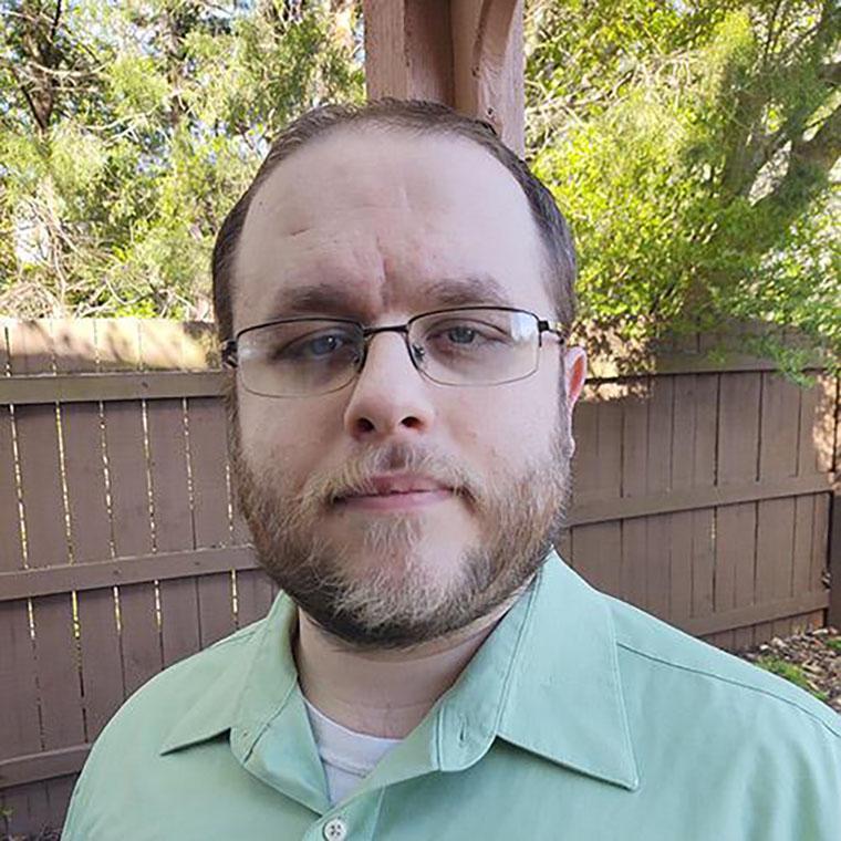 A man with glasses in a green shirt